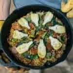 Michael holding a cast iron skillet filled with paella