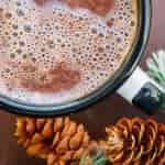 Nutella hot chocolate in a mug next to pinecones