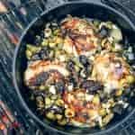 Chicken Marbella in a Dutch oven over a campfire