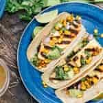 Three halloumi tacos on a blue camping plate