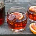 Negroni cocktail in a rocks glass on a wooden camping table.